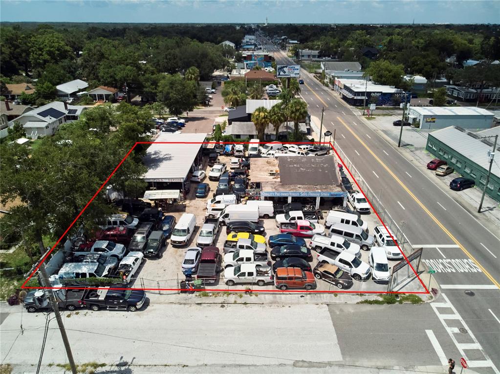 An aerial view shows a car dealership lot filled with vehicles next to a road — 6304 N FLORIDA AVENUE, TAMPA, FL