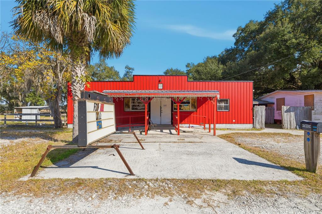 A bright red metal building with a front porch and a portable sign sits outdoors — 2451 SE HIGHWAY 41, MORRISTON, FL