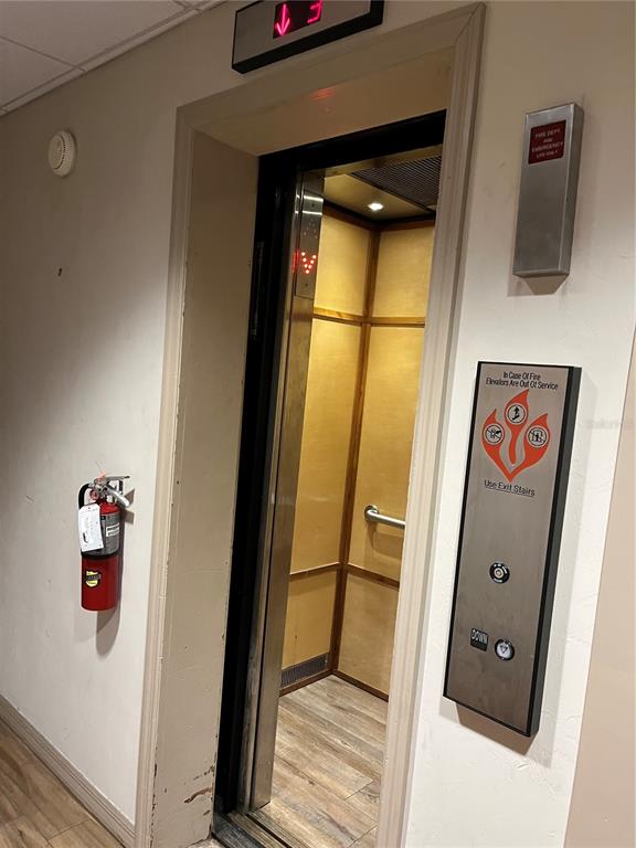 An elevator with wood-paneled walls and a fire extinguisher mounted on the adjacent wall — 204 W UNIVERSITY AVENUE UNIT 8, GAINESVILLE, FL