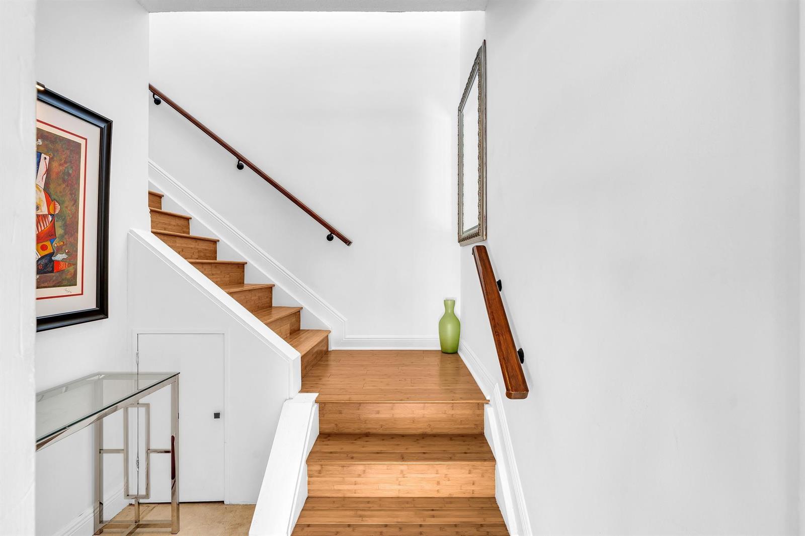 A staircase with light wood steps and two wooden handrails leads to a landing — 6666 Montego Bay Boulevard # B, Boca Raton FL 33433, BOCA RATON, FL