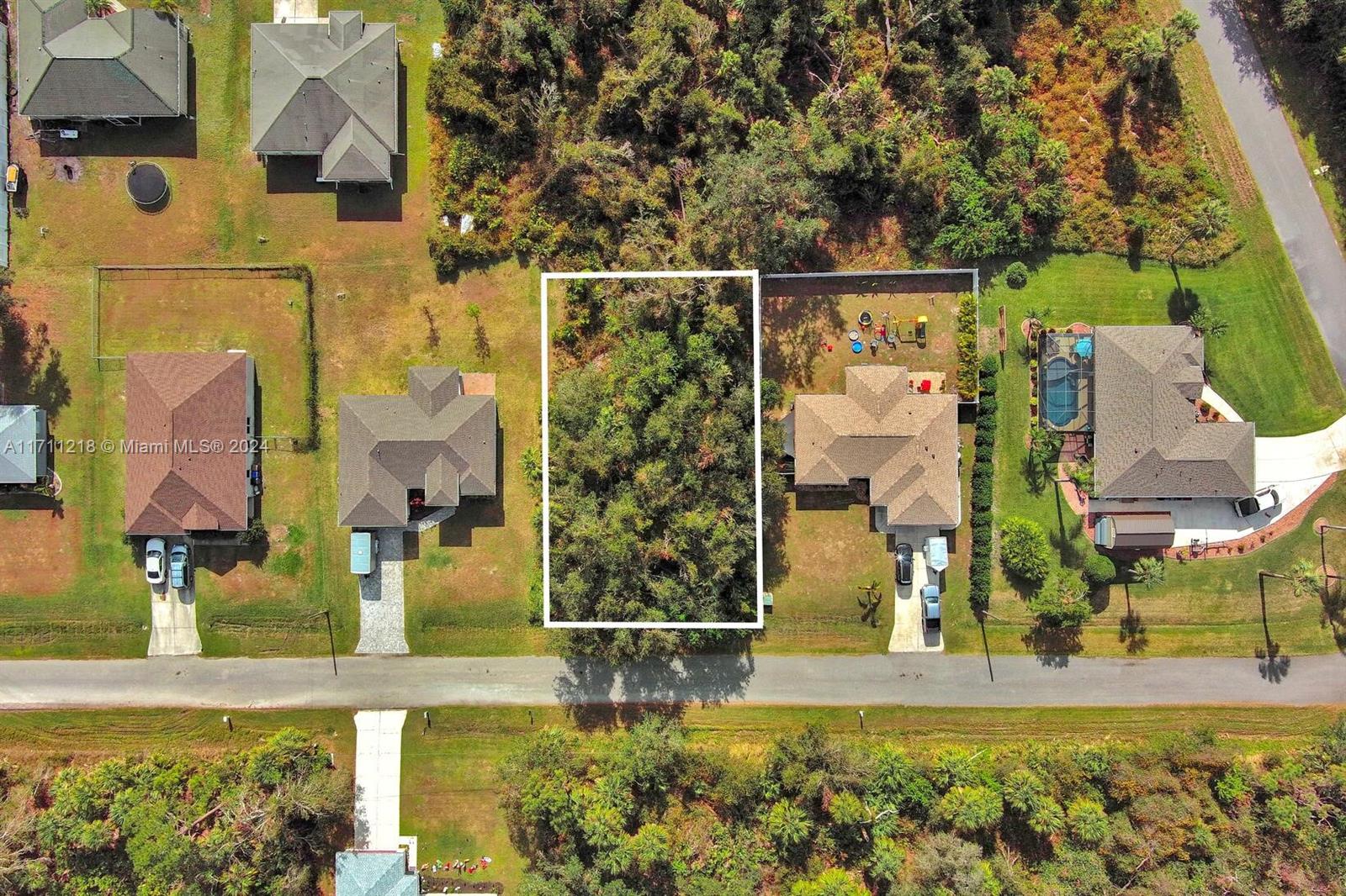 An aerial view shows a vacant, wooded residential lot situated between two existing houses — #3 Sargon Ave, North Port FL 34287, NORTH PORT, FL