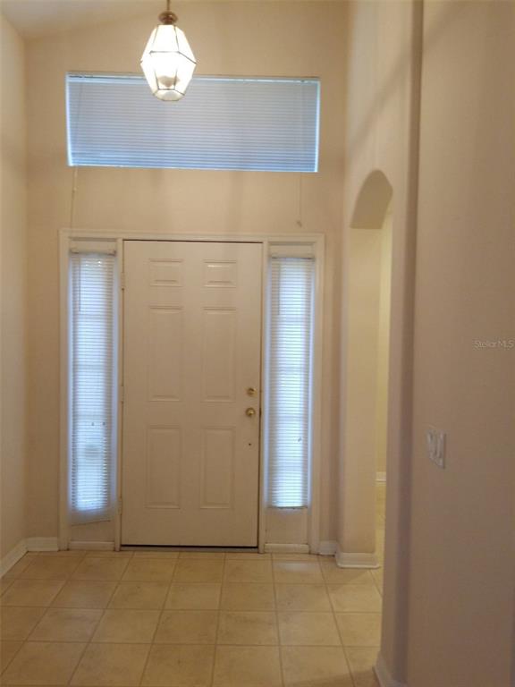 An entryway features a white front door with sidelights, a transom window, and tiled flooring — 19551 GLEN ELM WAY, ORLANDO, FL