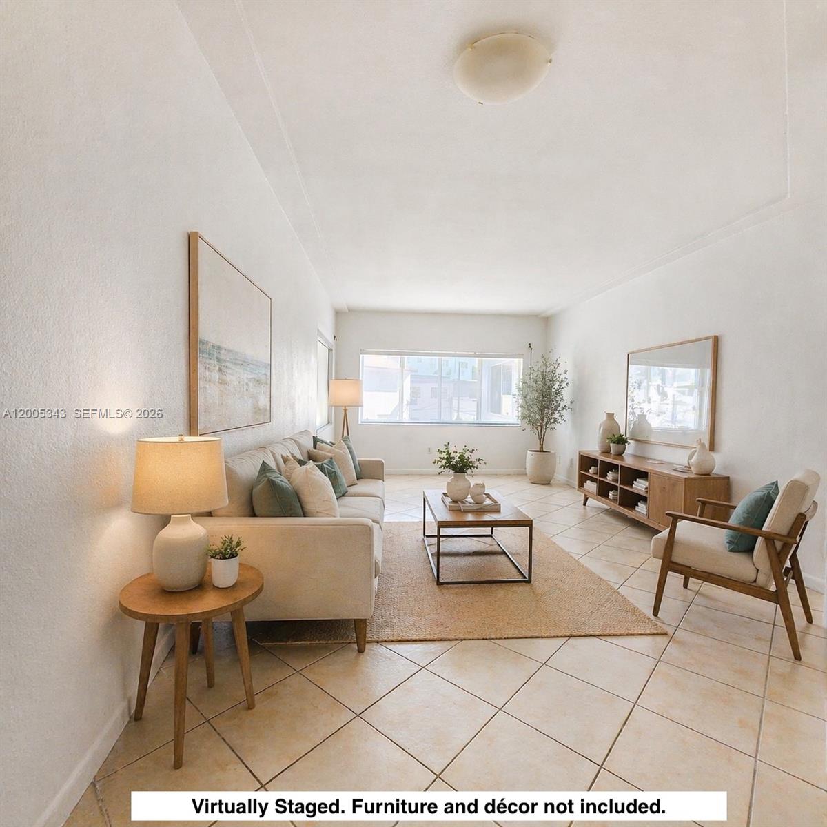 This living room features tile flooring, white walls, a large window, and virtual staging — 1185 Marseille Dr # 209, Miami Beach FL 33141, MIAMI BEACH, FL