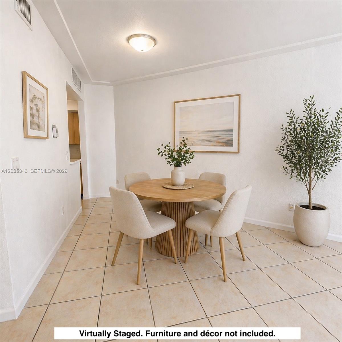 A dining area features a round wooden table, four chairs, and a potted plant — 1185 Marseille Dr # 209, Miami Beach FL 33141, MIAMI BEACH, FL
