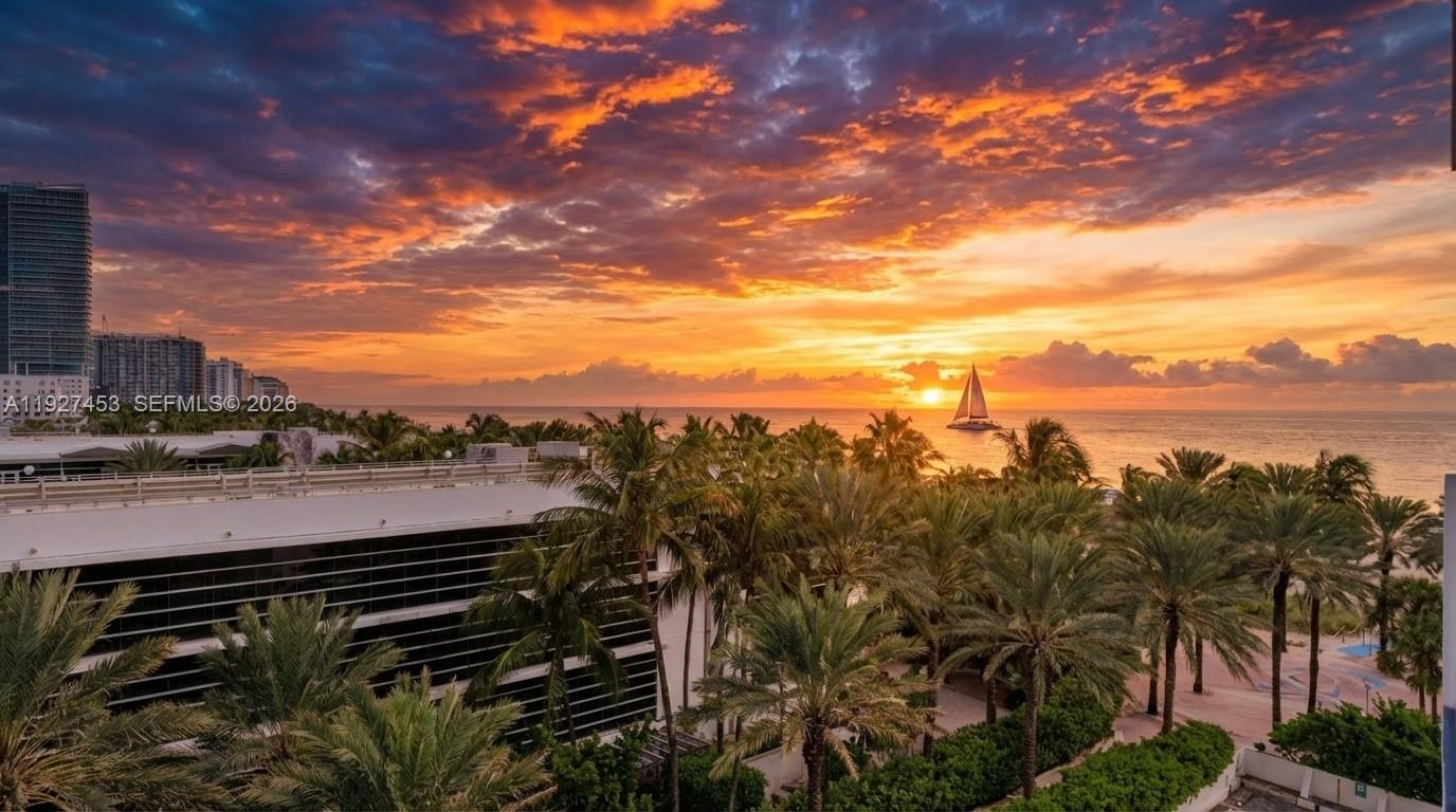 An elevated view of a sunset over the ocean with palm trees and a sailboat — 100 Lincoln Rd # 643, Miami Beach FL 33139, MIAMI BEACH, FL