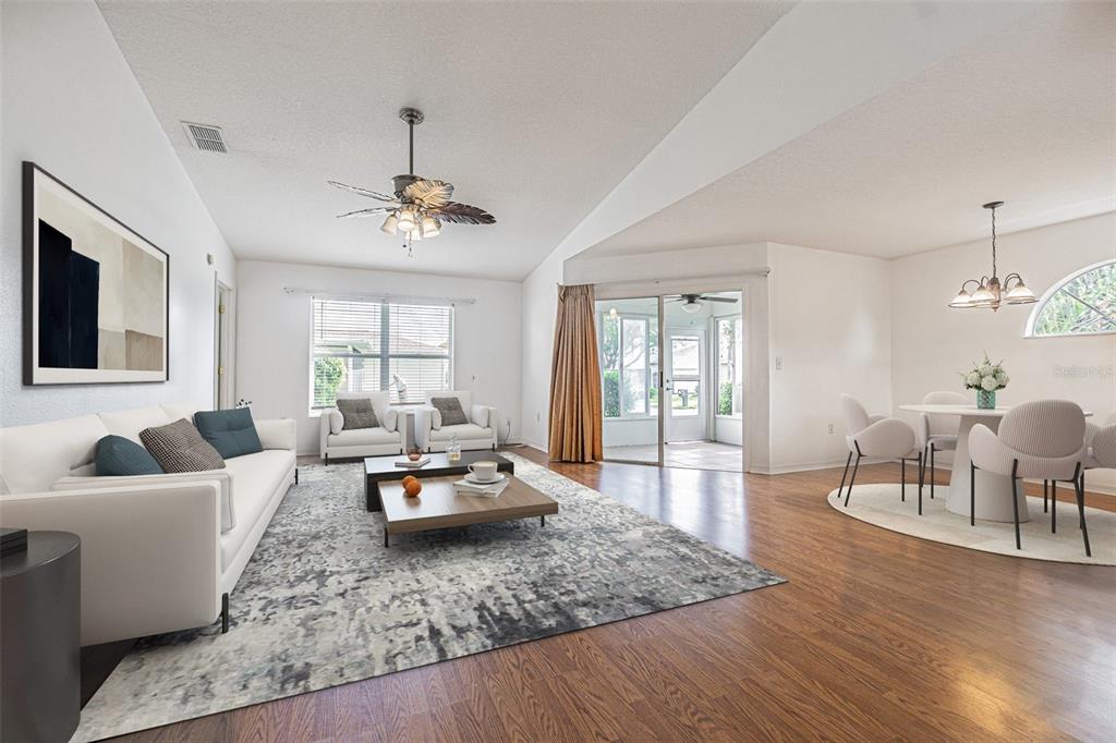 A living and dining area with white walls, wood flooring, and a large area rug — 11204 COREY PAVIN LANE, SAN ANTONIO, FL