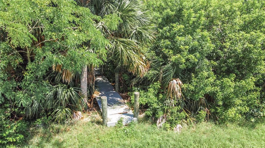 A wooden walkway leads into a dense area of trees and tropical foliage — 12411 CORAL VISTA CIRCLE, PLACIDA, FL