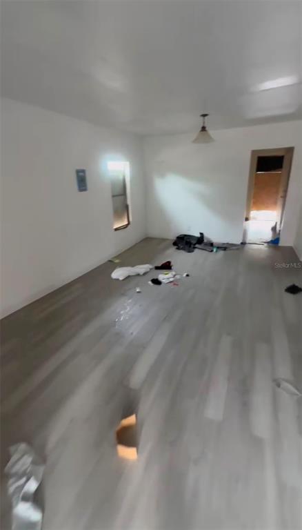 An empty room features light-colored wood-look flooring, white walls, and a single ceiling light fixture — 2516 E MAGNOLIA STREET, LAKELAND, FL