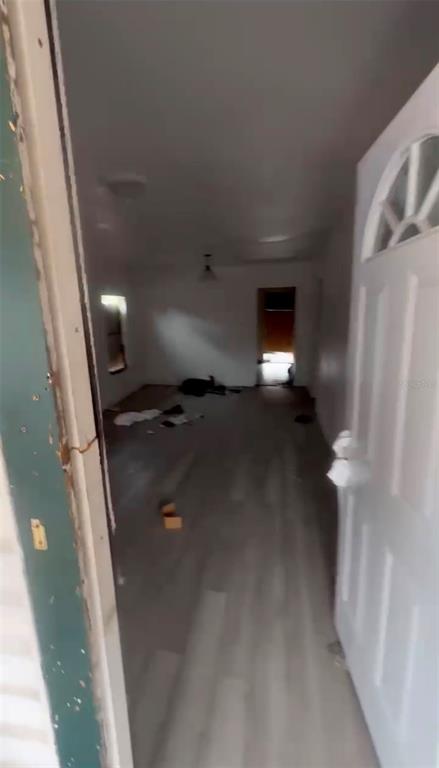 An interior view shows a sparsely furnished room with light-colored wood-look flooring and white walls — 2516 E MAGNOLIA STREET, LAKELAND, FL