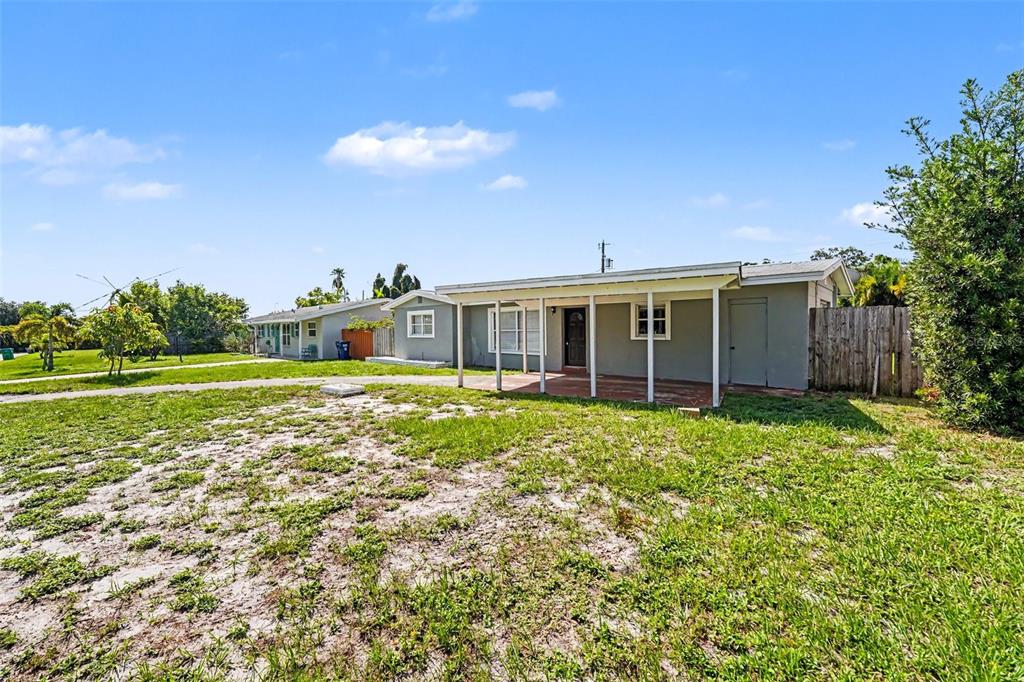 A gray single-story house with a covered front porch sits on a grassy lot — 11428 75TH AVENUE, SEMINOLE, FL