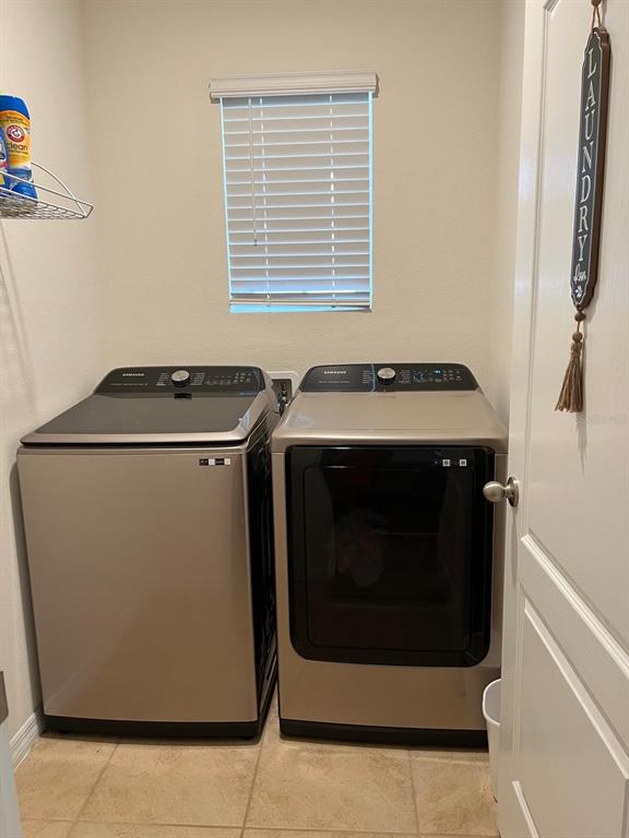 A laundry room featuring a top-load washer and a front-load dryer under a window — 1396 BERRY LANE, DAVENPORT, FL