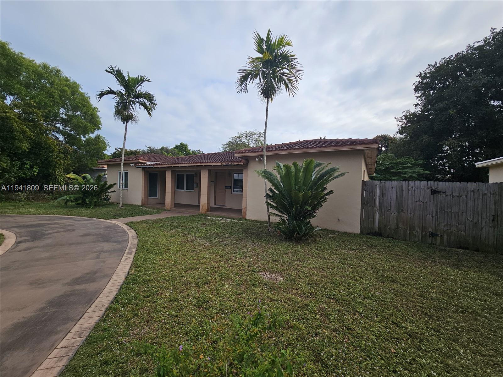 A single-story house with a beige exterior, a tiled roof, and palm trees in the yard — 1100 NE 115 # 0, Biscayne Park FL 33161, BISCAYNE PARK, FL