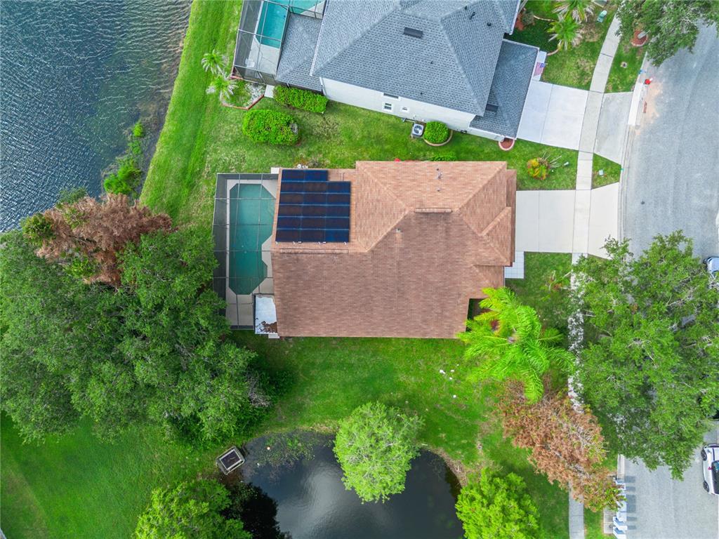 An aerial view shows a house with a solar panel array and a screened pool — 13635 WATERHOUSE WAY, ORLANDO, FL