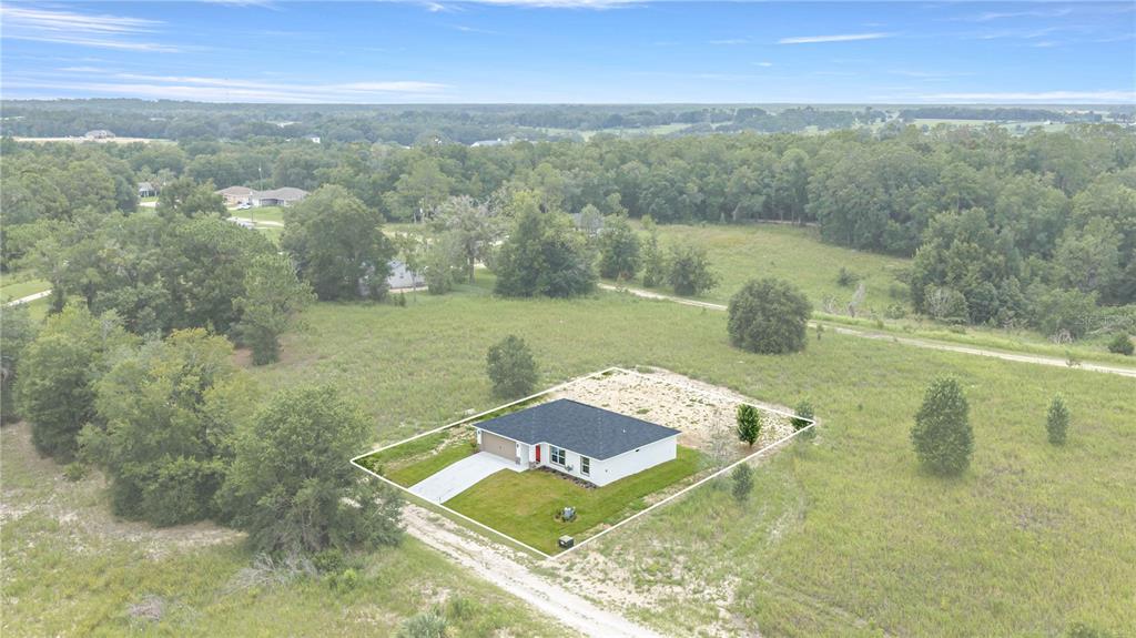An aerial view shows a single-story white house with a dark roof on a large lot — 14810 SW 33RD LANE, OCALA, FL