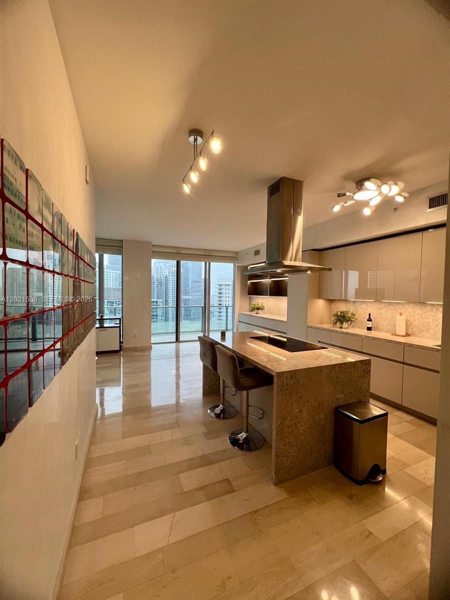 A living room features light wood floors, a white sofa, and large Eiffel Tower wall art — 1300 E Brickell Bay Dr # 3701, Miami FL 33131, MIAMI, FL