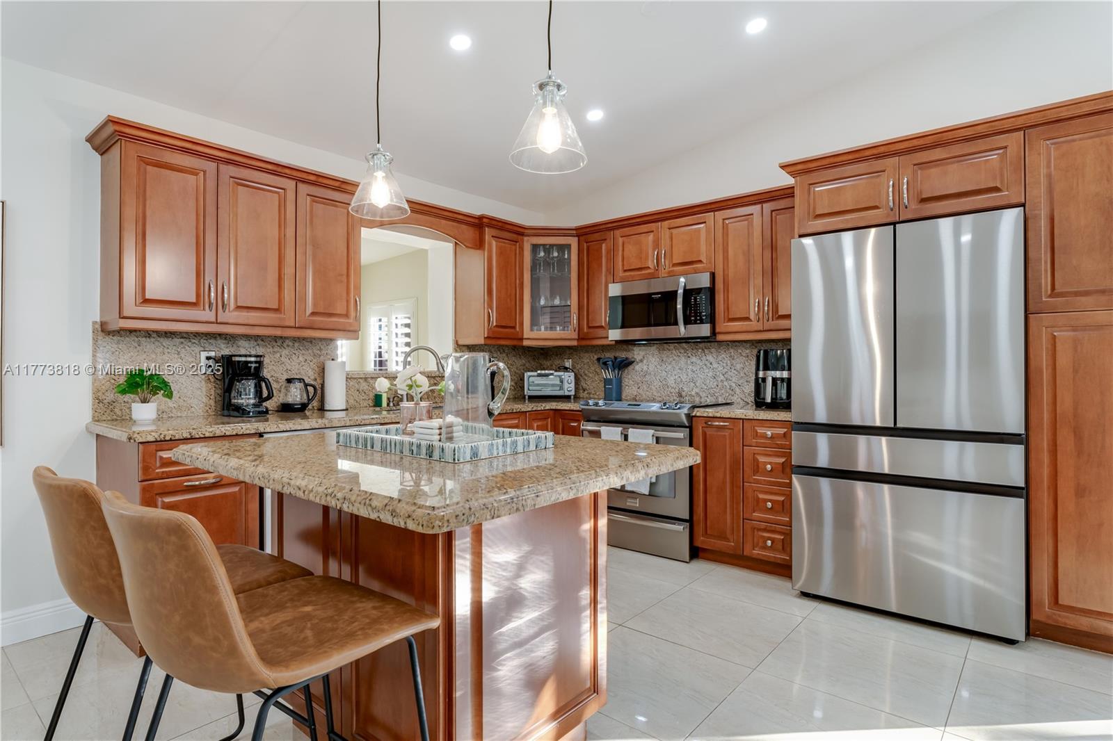 A kitchen features wood cabinets, granite countertops, stainless steel appliances, and a central island — 14517 SW 98th Ter, Miami FL 33186, MIAMI, FL