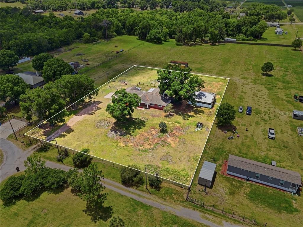 An aerial view shows a house with a large yard enclosed by a white boundary line — 303 KARPPE ROAD, PLANT CITY, FL