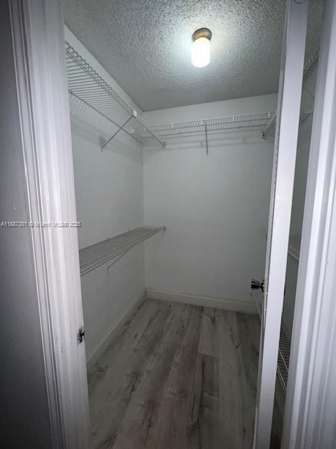 A walk-in closet with white walls, wire shelving, and light-colored wood-look flooring — 7001 Environ Blvd # 308, Lauderhill FL 33319, LAUDERHILL, FL