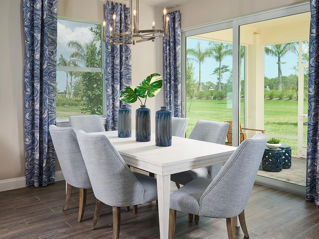 A dining room features a white table, light gray chairs, blue curtains, and patio views — 392 BIRKDALE DRIVE, DAYTONA BEACH, FL