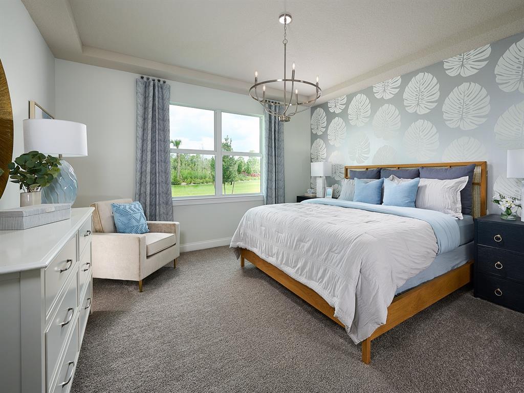 A bedroom features a patterned accent wall, a wooden bed frame, and a large window — 392 BIRKDALE DRIVE, DAYTONA BEACH, FL