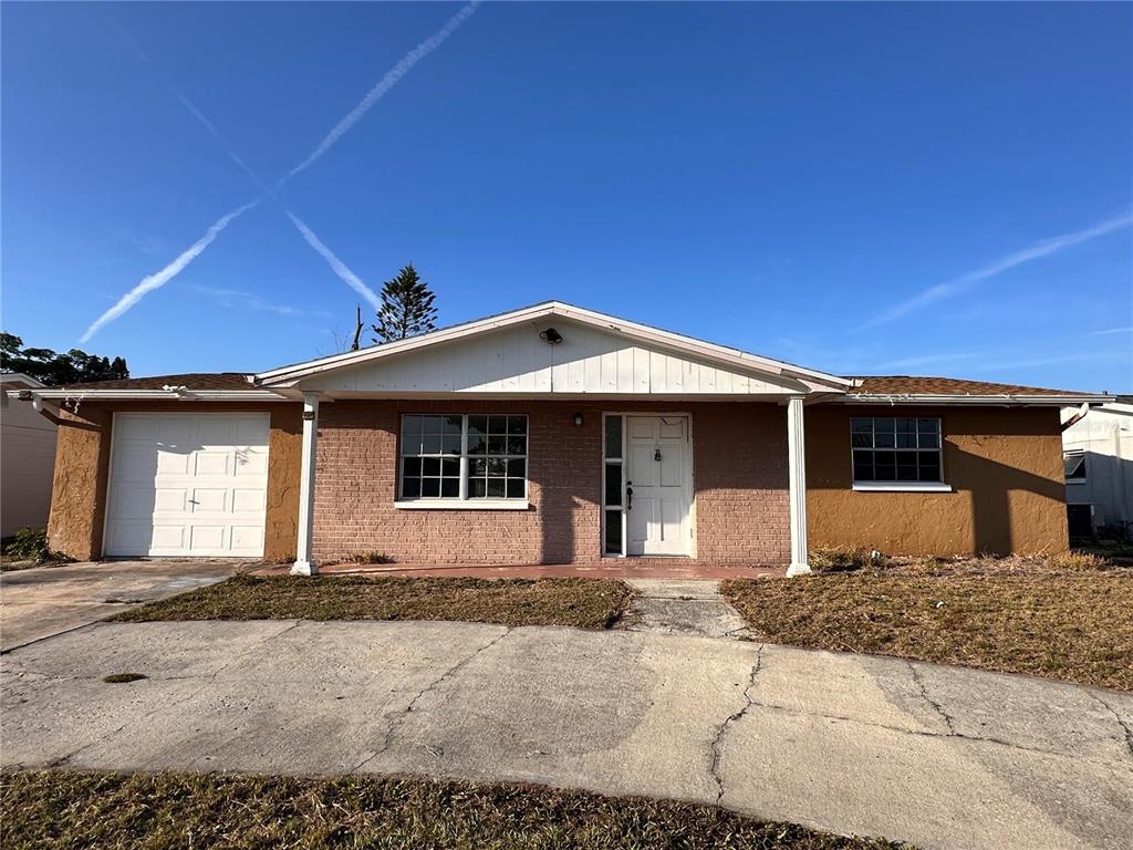 A single-story house with a brick facade, a white front door, and an attached garage — 3215 BRIGHT DRIVE, HOLIDAY, FL