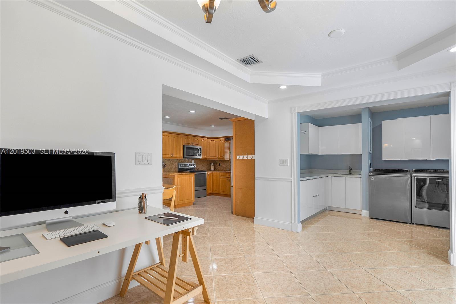 A home office area opens into a kitchen and a laundry room with white cabinets — 3021 N 72nd Way, Hollywood FL 33024, HOLLYWOOD, FL