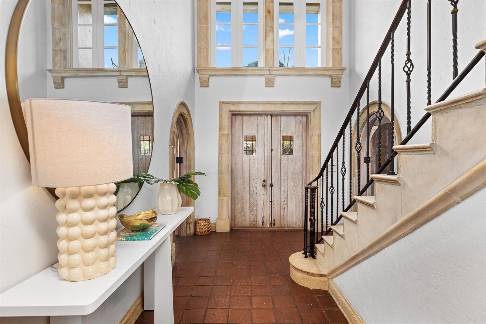 A foyer features a terracotta tile floor, a wooden double door, and a stone staircase — 124 Brazilian Avenue, Palm Beach FL 33480, PALM BEACH, FL