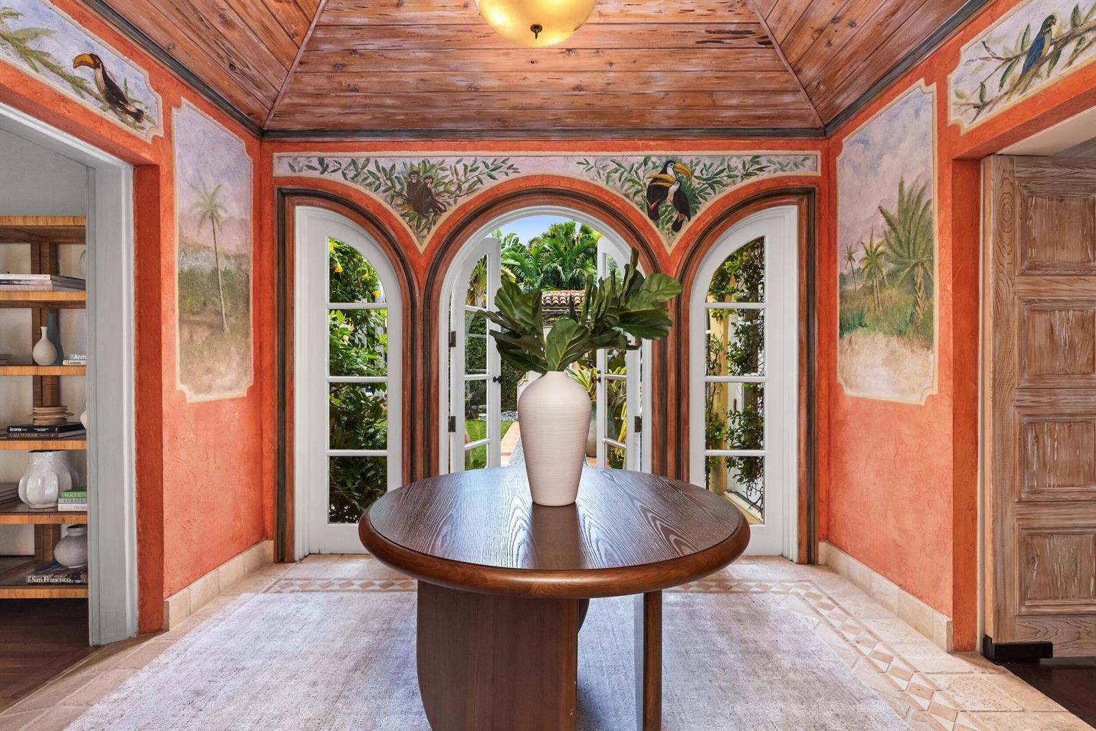 A foyer features orange walls with tropical murals, a wooden ceiling, and arched glass doors — 124 Brazilian Avenue, Palm Beach FL 33480, PALM BEACH, FL