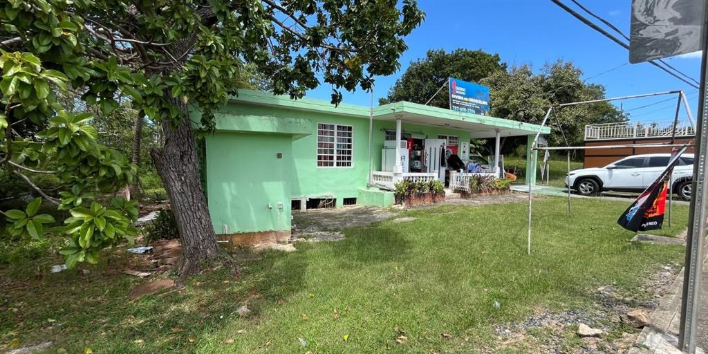 A light green, single-story building with a covered porch sits on a grassy lot — CARR NÚM. 458 KM 1.5 BO MUNICIPIO, AGUADILLA, PR