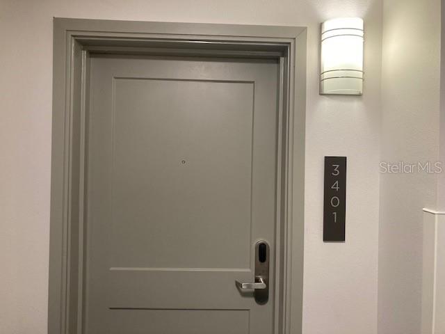A gray door with a modern handle and a vertical address sign labeled 3401 — 14501 GROVE RESORT AVENUE UNIT 3401, WINTER GARDEN, FL