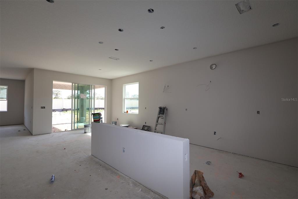 A modern kitchen features light gray cabinets, stainless steel appliances, and a herringbone tile backsplash — 3539 WOLVES CREEK PLACE, APOPKA, FL