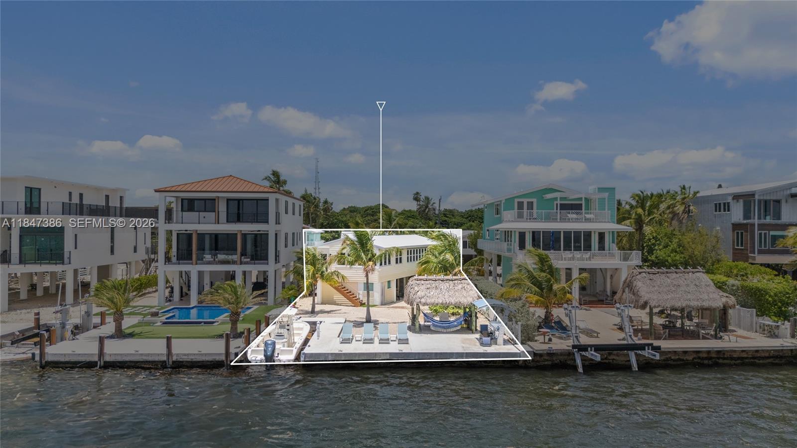 An aerial view shows a waterfront house with a dock, boat, and tiki hut — 235 Tavernier Dr, Key Largo FL 33070, KEY LARGO, FL