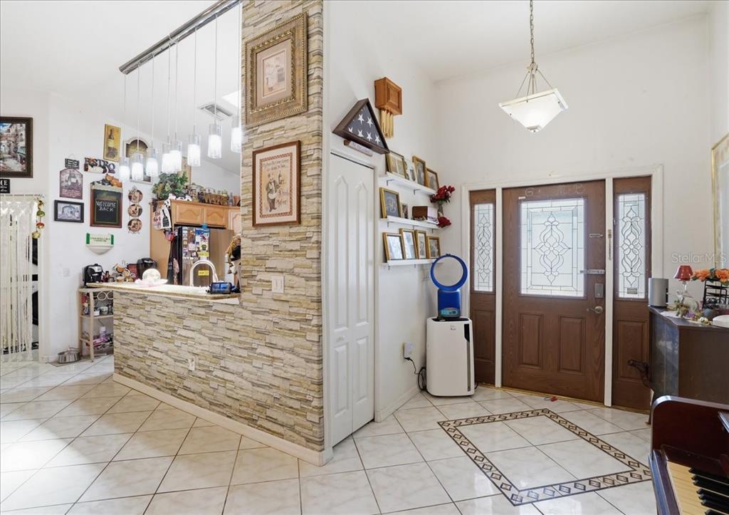 An entryway with tile floors leads to a kitchen featuring a stone-faced breakfast bar — 6993 MANNIZ ROAD, PORT CHARLOTTE, FL