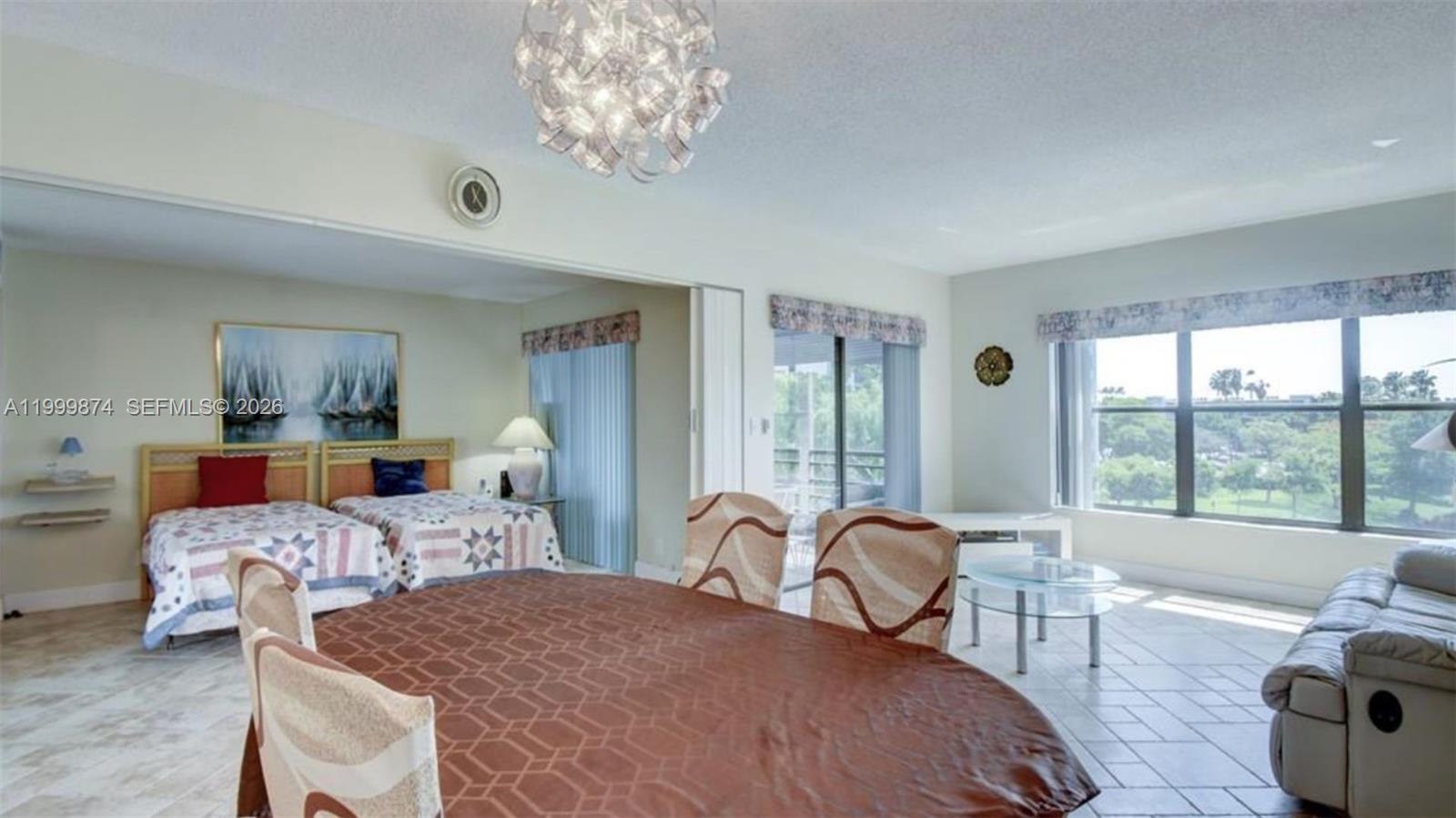 A dining area with a round table opens into a bedroom and a living space — 2311 S Cypress Bend Dr # 419A, Pompano Beach FL 33069, POMPANO BEACH, FL