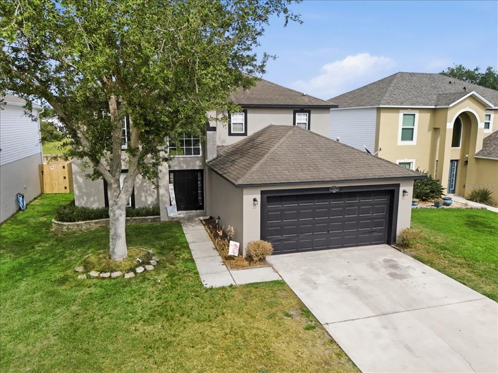An aerial view of a two-story suburban house with a gray exterior and attached garage — 1038 MACON DRIVE, TITUSVILLE, FL