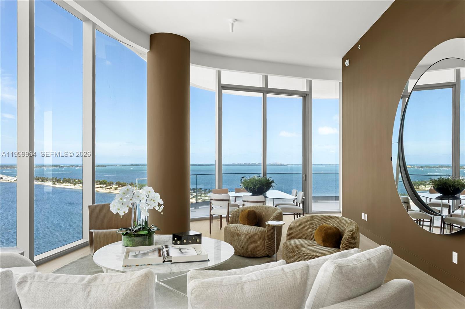 A living room with floor-to-ceiling windows, a circular mirror, and panoramic ocean views — 175 SE 25th Rd # 1501, Miami FL 33129, MIAMI, FL