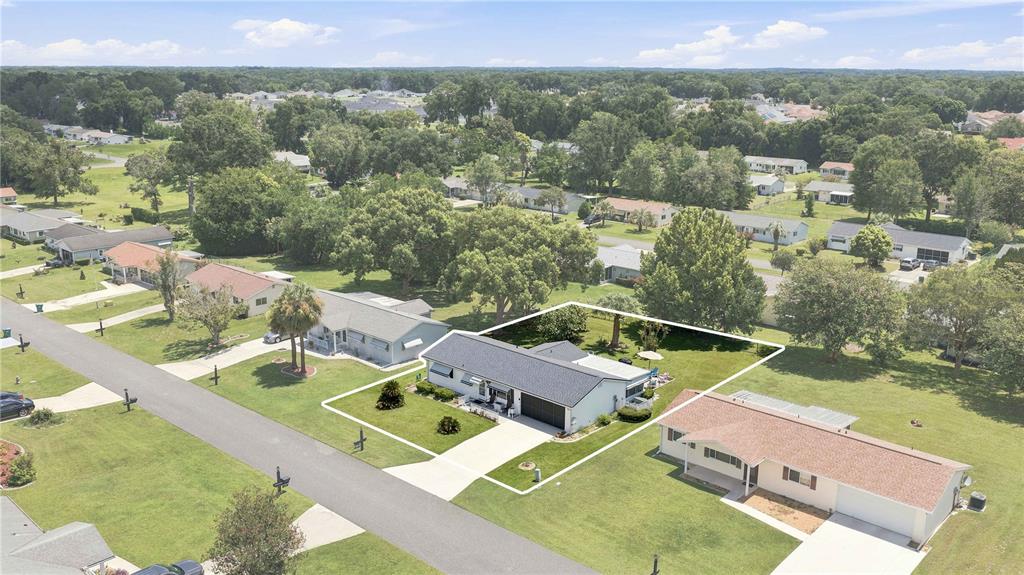 An aerial view shows a single-story house with a white exterior and a dark roof — 11151 SW 76TH AVENUE, OCALA, FL