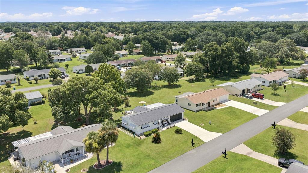 An aerial view shows several single-story houses surrounded by green lawns and mature trees — 11151 SW 76TH AVENUE, OCALA, FL