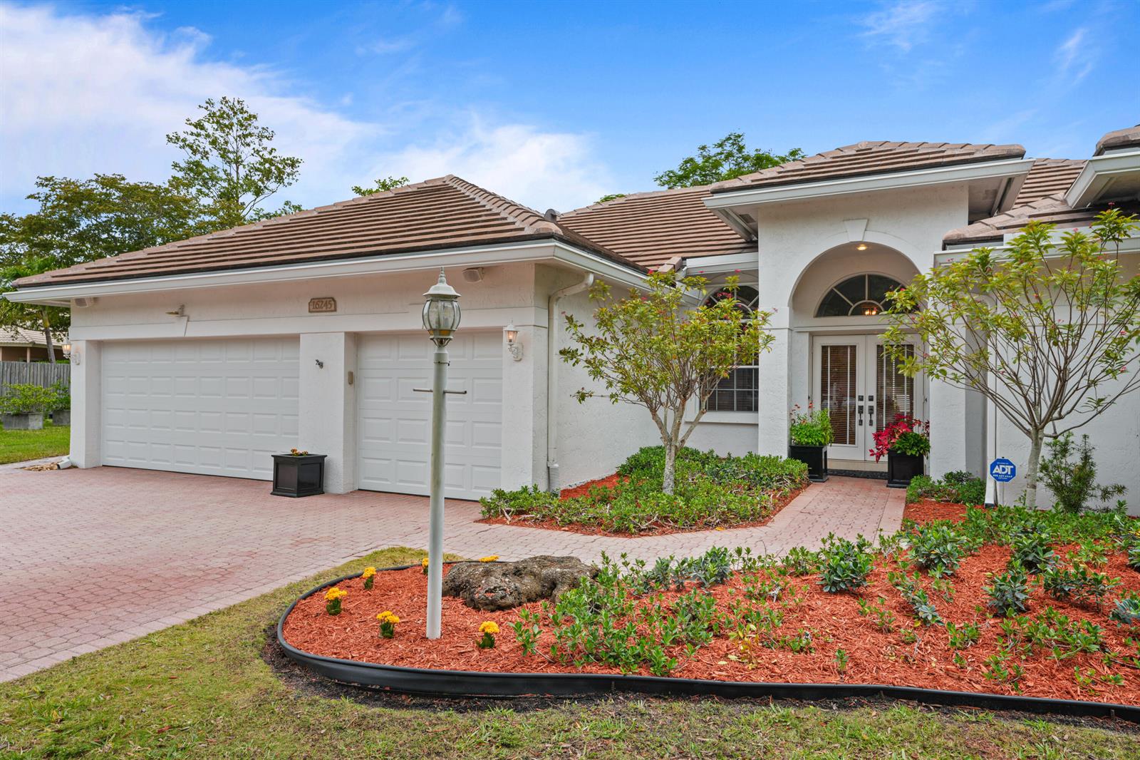 A single-story house with a two-car garage, tile roof, and landscaped front yard — 16245 Seneca Circle, Davie FL 33331, DAVIE, FL