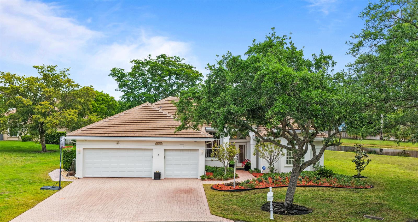 A single-story house with a two-car garage, tile roof, and a large tree in front — 16245 Seneca Circle, Davie FL 33331, DAVIE, FL