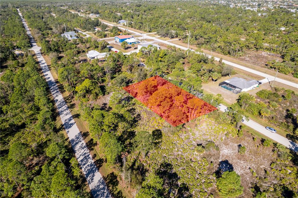 An aerial view shows a rectangular, wooded vacant lot highlighted in red — 26335 GLASPELL ROAD, PUNTA GORDA, FL