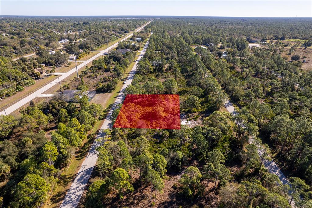 An aerial view shows a rectangular plot of land highlighted in red along a road — 26335 GLASPELL ROAD, PUNTA GORDA, FL