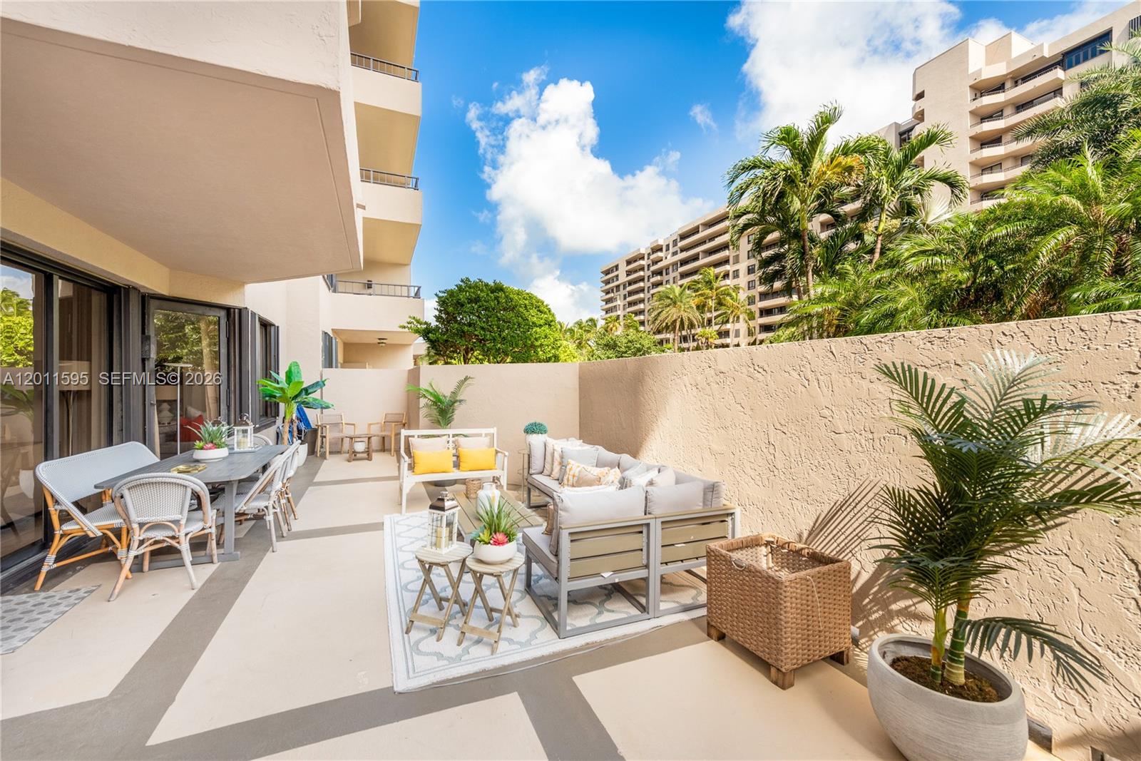 A spacious outdoor patio features a dining area and lounge seating with potted plants — 201 Crandon Blvd # 138, Key Biscayne FL 33149, KEY BISCAYNE, FL