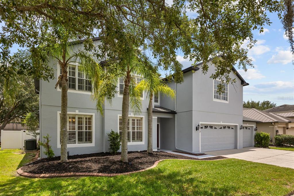 A two-story gray house with a three-car garage and palm trees in the front yard — 1573 ANNA CATHERINE DRIVE, ORLANDO, FL