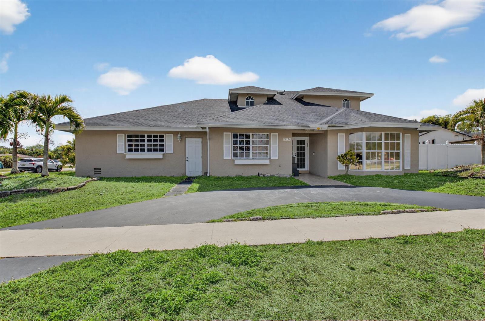 A single-story house with a gray roof, tan stucco exterior, and a curved driveway — 21724 Little Bear Way, Boca Raton FL 33428, BOCA RATON, FL