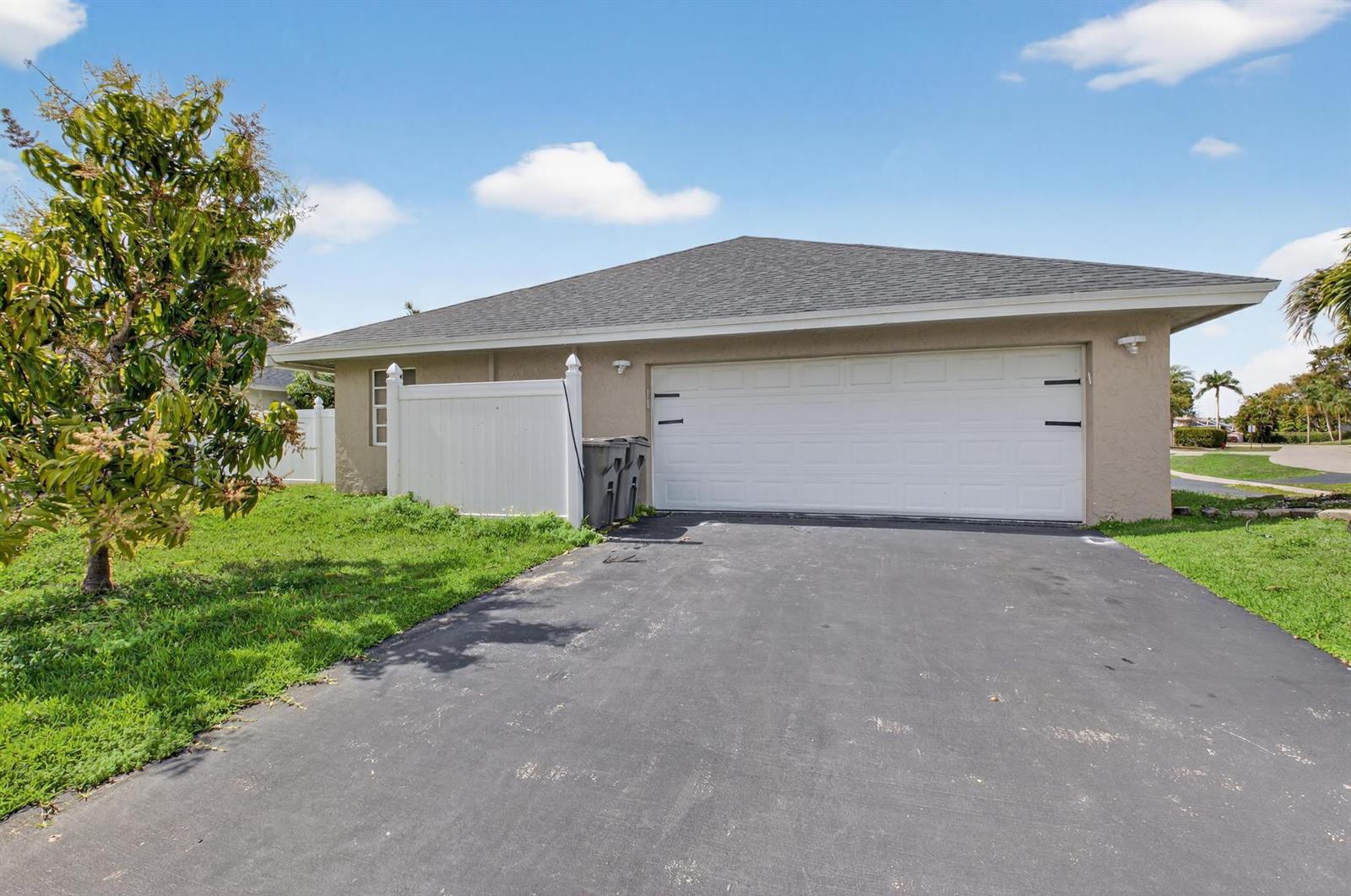 A beige house with a white garage door and a white privacy fence — 21724 Little Bear Way, Boca Raton FL 33428, BOCA RATON, FL