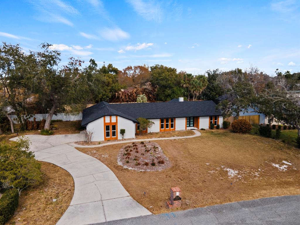 An aerial view of a white single-story house with a dark roof and wooden trim — 7337 BRANCHTREE DRIVE, ORLANDO, FL
