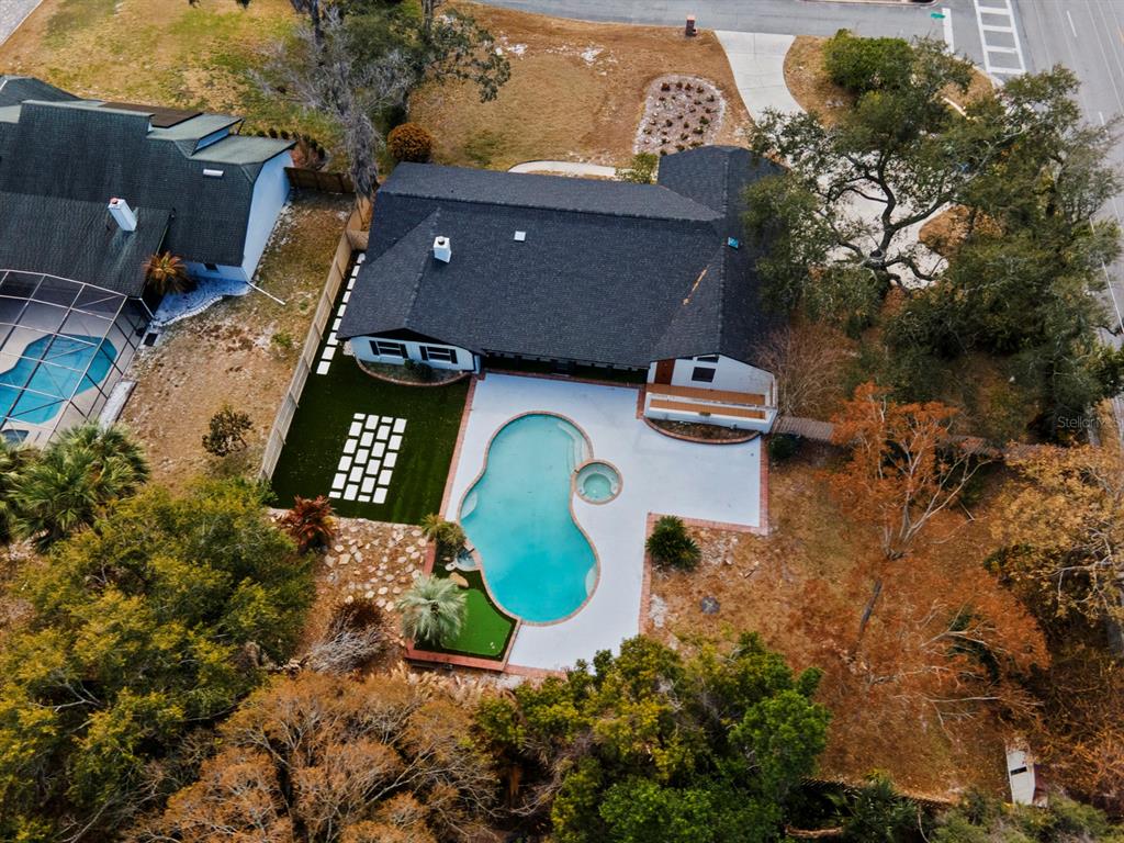 An aerial view shows a house with a dark roof, a swimming pool, and landscaping — 7337 BRANCHTREE DRIVE, ORLANDO, FL