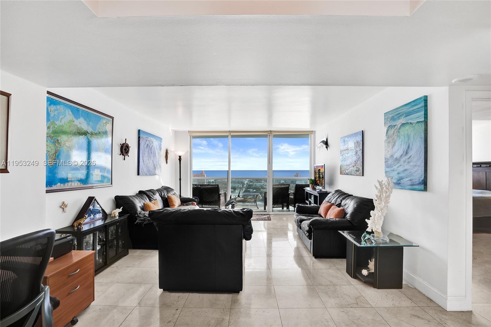 A living room features black leather sofas, tile flooring, and a balcony with ocean views — 650 West Ave # 2206, Miami Beach FL 33139, MIAMI BEACH, FL