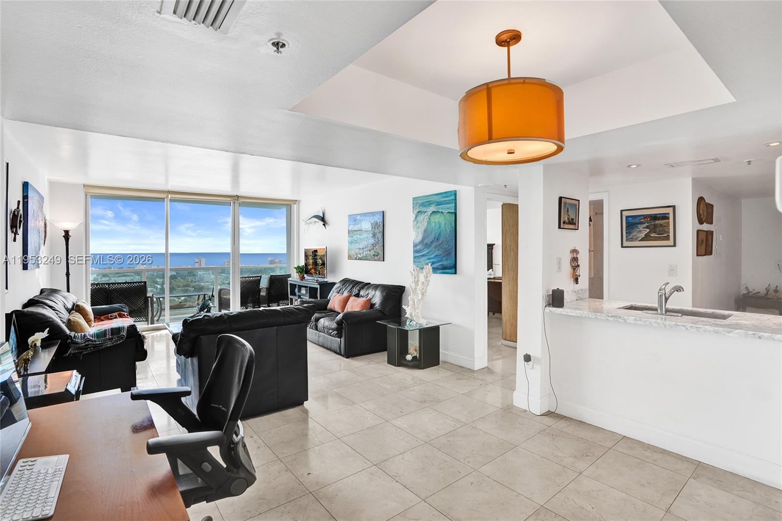 A living room with tile floors, black leather furniture, and a view of the ocean — 650 West Ave # 2206, Miami Beach FL 33139, MIAMI BEACH, FL